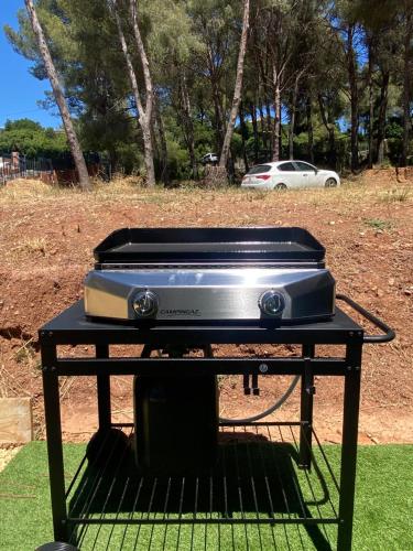 a grill on a table with a car in the background at Joli mas bohème 60 m carré a seulement une minute à pied de la plage 4 personnes in Le Pradet