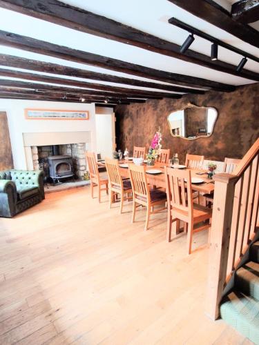 a dining room with a table and chairs and a fireplace at Historic Rothbury Gem- West End House in Rothbury