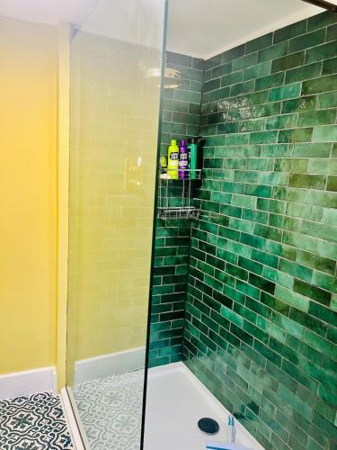 a bathroom with a shower with green tile at Historic Rothbury Gem- West End House in Rothbury
