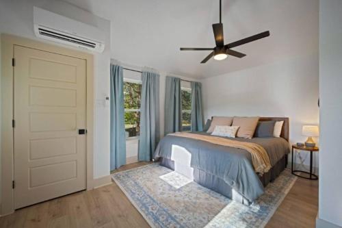 une chambre avec un lit et un ventilateur de plafond dans l'établissement NEW Campfire Cottage River Access Shared Pool, à Wimberley