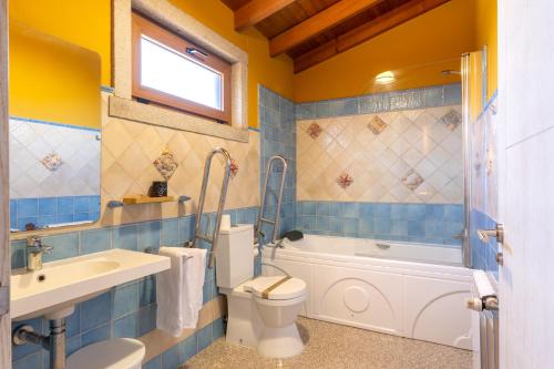 a bathroom with a toilet and a sink and a tub at Apartamento Pescadeira de Agar in Rego de Santa Marina