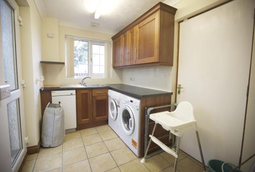 a kitchen with a washing machine and a sink at Woodlands in Newquay