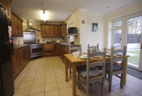 a kitchen with a wooden table and a table and chairs at Woodlands in Newquay