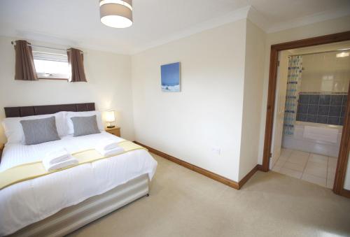 a bedroom with a large bed and a bathroom at Woodlands in Newquay