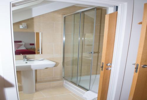 a bathroom with a shower and a sink at The Treyarnon Suite in St Merryn