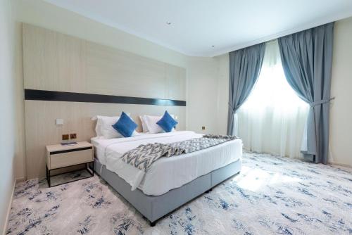 a bedroom with a large bed and a window at Sumou Hotel Al Khobar in Al Khobar