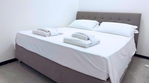 a white bed with two towels on top of it at Teodorico 21 Center & Comfort in Ravenna