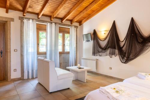 a bedroom with two beds and a chair and a window at Apartamento Pescadeira de Agar in Rego de Santa Marina