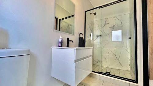 a white bathroom with a shower and a sink at 745@TheBlyde in Pretoria
