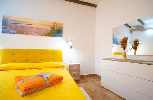 a bedroom with a yellow bed with a yellow headboard at B&B Sinis Domus in Siniscola