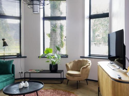 a living room with a chair and a television at Kiel Windeweer - Eindeloos uitzicht in Kiel