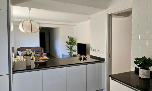 a kitchen with white cabinets and a black counter top at Casa Esmeralda, piscina, estacionamento, AC, Wifi in Olhão