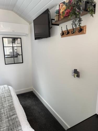 a room with a bed and a tv on the wall at The West Wing in Bournemouth