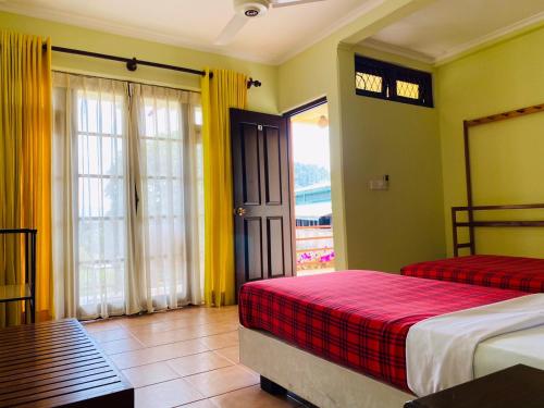 a hotel room with two beds and a window at Nature Walk Resort in Kandy