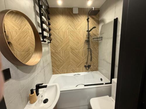 a bathroom with a toilet and a sink and a tub at WRZOS resort & wellness in Węgierska Górka