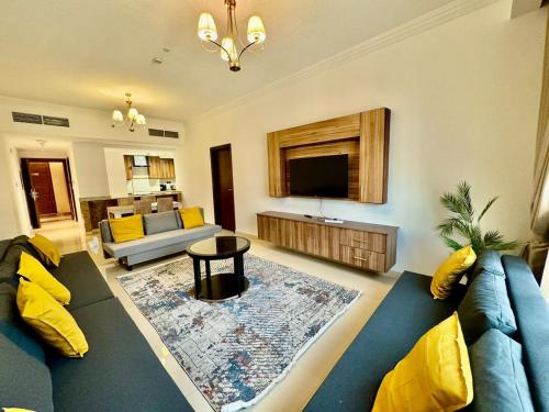 a living room with a blue couch and a tv at JSCOM Grand Residence ABU HAIL in Dubai