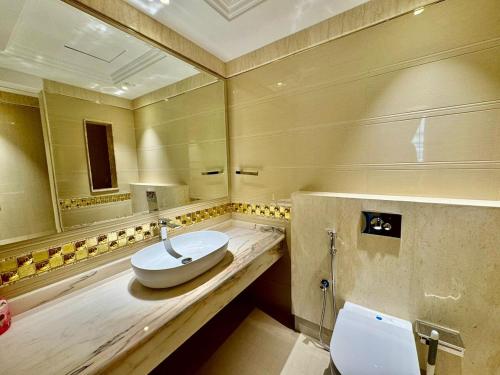 a bathroom with a sink and a toilet at JSCOM Grand Residence ABU HAIL in Dubai