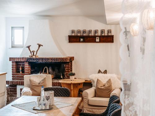 a living room with a table and chairs and a fireplace at Hotel Garni Kern in Halfing