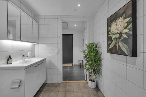 ein Badezimmer mit einem Waschbecken und einer Pflanze darin in der Unterkunft Northstay - Tromsø Outlook, Amazing City & Mountain Views in Tromsø