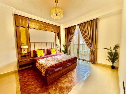 a bedroom with a bed and a large window at JSCOM Grand Residence ABU HAIL in Dubai