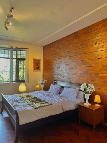 a bedroom with a large bed with a brick wall at Tropical Lux 5BR Villa Panoramic Isola Bandung in Bandung