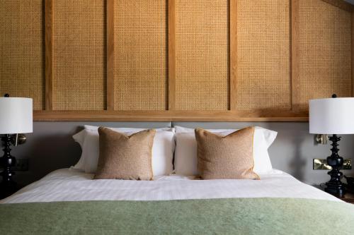 a bedroom with a white bed with two lamps at The Hampshire Hog in Clanfield