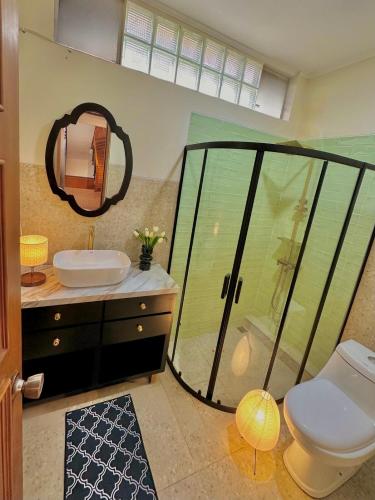 a bathroom with a shower and a toilet and a sink at Tropical Lux 5BR Villa Panoramic Isola Bandung in Bandung