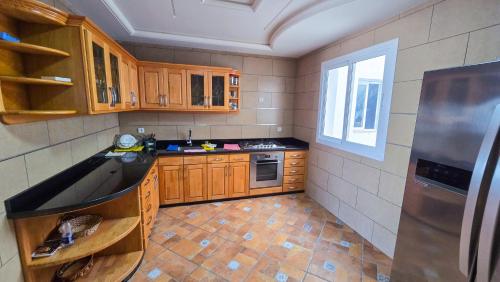 a small kitchen with wooden cabinets and a window at L'unico - Sea View, Pool & Jaccuzi in Oued Laou