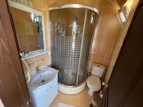 a bathroom with a shower and a sink and a toilet at Grand Alver Otel in Edremit