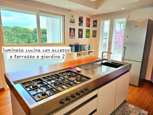 a kitchen with a stove top oven next to a window at CasaVacanze Nichi vista mare in Grottammare
