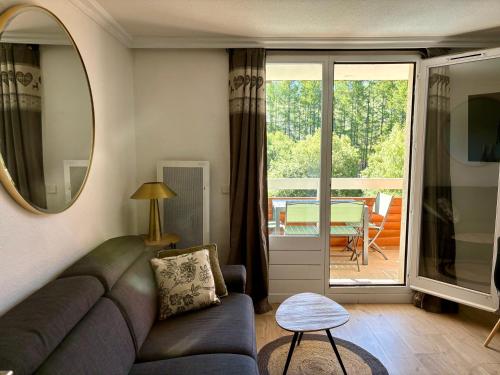 d'un salon avec un canapé et un balcon. dans l'établissement Pierre et Vacances Les Bergers au Pied des pistes & Piscine -Sauna & Balcon Sud, à L'Alpe-d'Huez