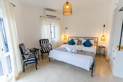 a bedroom with a bed with blue pillows and chairs at Zalihe Boutique Hotel North Nicosia in Nicosia
