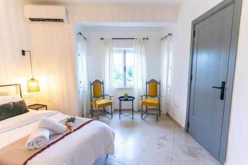 a bedroom with a bed with two chairs and a table at Zalihe Boutique Hotel North Nicosia in Nicosia
