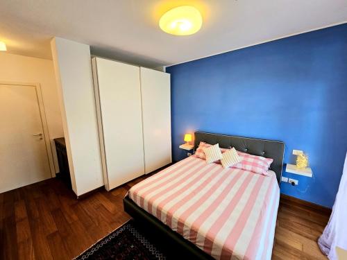 a blue bedroom with a bed with a striped blanket at CasaVacanze Nichi vista mare in Grottammare