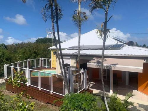 a house with a pool and palm trees at Maison cosy à Saint-François avec piscine in Saint-François