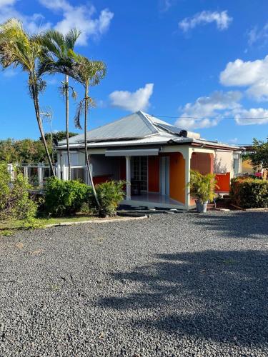 a house with palm trees in front of it at Maison cosy à Saint-François avec piscine in Saint-François