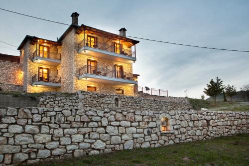 a stone wall with a building on top of it at Kaloneri Rooms in Kaloneri
