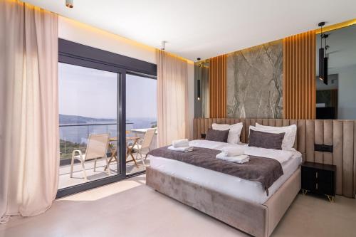 a bedroom with a large bed and a balcony at Green Sunrise Villa in Brsečine