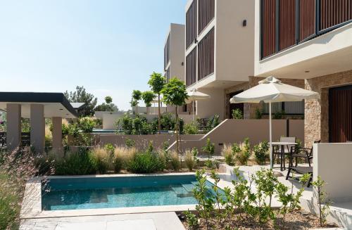 a swimming pool in front of a building at Anore Luxury Suites in Nikiti