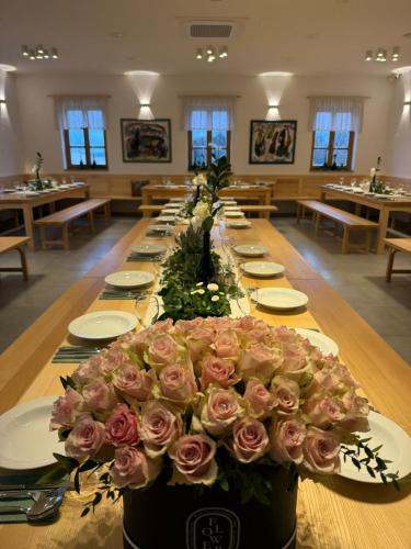 a long table with a large bouquet of pink roses at Rooms at Podlipje Estate in Tešanovci