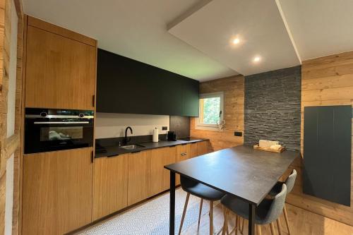 une cuisine avec une table et un comptoir noir dans l'établissement Cozy Home For 2 Megève, à Megève