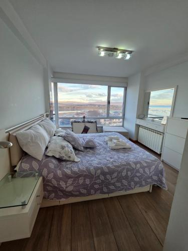 a bedroom with a bed and a large window at Dreamy views in Ushuaia