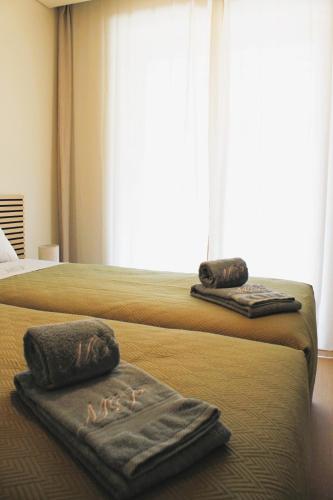 two beds in a hotel room with towels on them at Beachside 2 BD Apartment | Balcony | AC in Vila Nova de Gaia