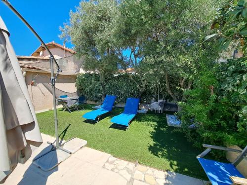 a group of blue chairs sitting on the grass at Chez J-JM in Marseille