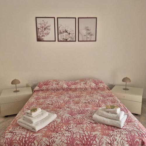 a bedroom with a bed with three pictures on the wall at Casa Vacanza Magna Graecia in Eboli