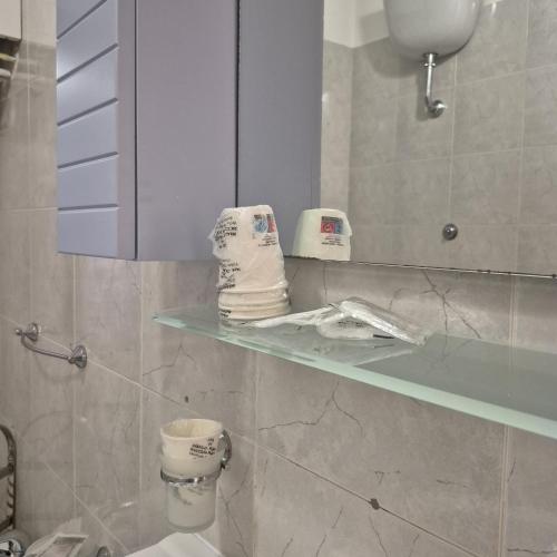 a bathroom with a sink and a shelf with towels at Casa Vacanza Magna Graecia in Eboli