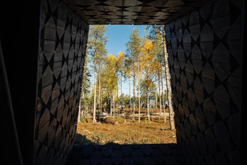 okno w budynku z widokiem na las drzew w obiekcie Apukka Resort w mieście Rovaniemi