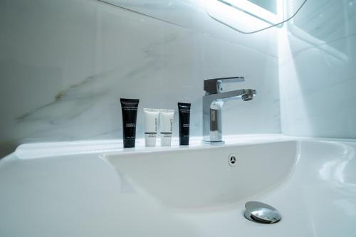 - un lavabo avec un robinet et des brosses à dents dans l'établissement Eden hotel, à Tirana