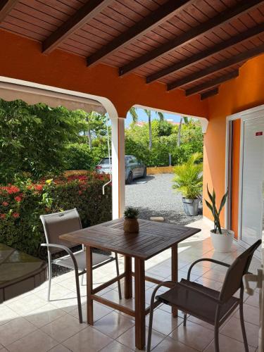 a wooden table and chairs on a patio at Maison avec terrasse à Saint-François - 50 m² avec spa in Saint-François