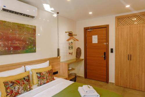a bedroom with a bed and a wooden door at Uva Rooms in Fethiye